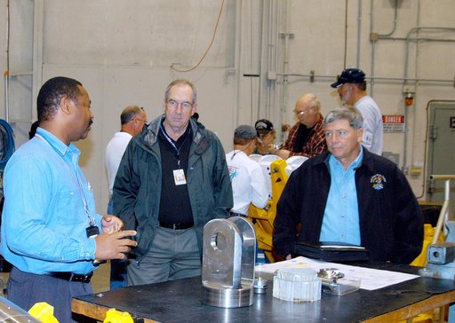 KENNEDY SPACE CENTER, FLA. -- From left, a United Space Alliance (USA) technician discusses aspects of Shuttle processing performed in the Solid Rocket Booster (SRB) Assembly and Refurbishment Facility (ARF) with USA Vice President and Space Shuttle Program Manager Howard DeCastro and NASA Deputy As