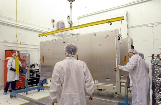 VANDENBERG AFB, CALIF. - Workers in the NASA spacecraft processing facility on North Vandenberg Air Force Base prepare to rotate the framework containing one of four solar panels to be installed on the Gravity Probe B spacecraft.  Installing each array is a 3-day process and includes a functional de