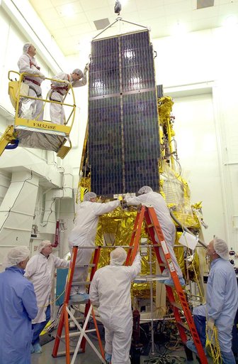 VANDENBERG AFB, CALIF. - Workers in the NASA spacecraft processing facility on North Vandenberg Air Force Base attach a solar array panel on the Gravity Probe B spacecraft.  Installing each array is a 3-day process and includes a functional deployment test.  The Gravity Probe B mission is a relativi