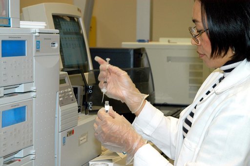 KENNEDY SPACE CENTER, FLA. -- In the Space Life Sciences Lab, Lanfang Levine, with Dynamac Corp., transfers material into a sample bottle for analysis.  She is standing in front of new equipment in the lab that will provide gas chromatography and mass spectrometry.  The equipment will enable analysi
