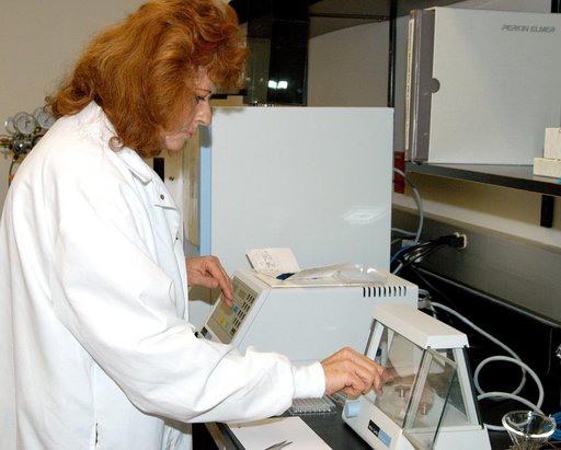 KENNEDY SPACE CENTER, FLA. -- In the Space Life Sciences (SLS) Lab, Jan Bauer, with Dynamac Corp., places samples of onion tissue in the elemental analyzer, which analyzes for carbon, hydrogen, nitrogen and sulfur. The 100,000 square-foot SLS houses labs for NASA’s ongoing research efforts, microbio