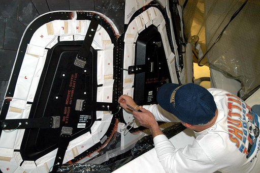 KENNEDY SPACE CENTER, FLA. -- Les Hanks, with United Space Alliance, prepares a window on Atlantis for removal.  The windows are being removed to inspect them for contaminants in the thermal seal.  Atlantis has been undergoing routine maintenance in the Orbiter Processing Facility for Return to Flig