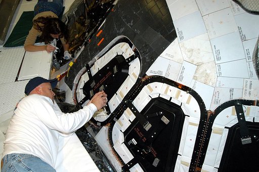 KENNEDY SPACE CENTER, FLA. -- Les Hanks (foreground) and Darlene Beville (background), with United Space Alliance,  prepare a window on Atlantis for removal.  The windows are being removed to inspect them for contaminants in the thermal seal.  Atlantis has been undergoing routine maintenance in the 