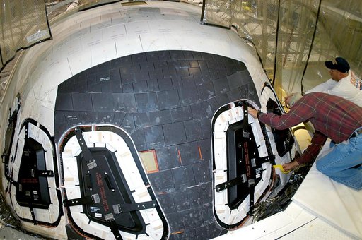 KENNEDY SPACE CENTER, FLA. -- At right, Mike Young and Les Hanks, with United Space Alliance, prepare a window on Atlantis for removal.  The windows are being removed to inspect them for contaminants in the thermal seal.  Atlantis has been undergoing routine maintenance in the Orbiter Processing Fac