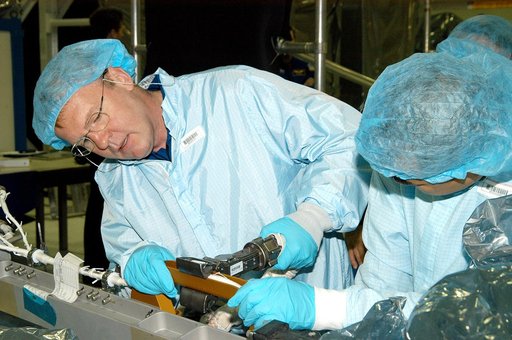 KENNEDY SPACE CENTER, FLA. -  In the Space Station Processing Facility, STS-114 Mission Specialist Andrew Thomas (left) works with equipment while Mission Specialist Soichi Noguchi watches.  Noguchi is with the Japanese Aerospace Exploration Agency (JAXA).  They and other crew members are at KSC for
