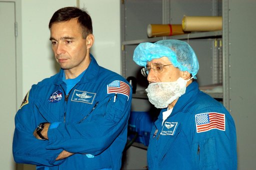 KENNEDY SPACE CENTER, FLA. -  In the Space Station Processing Facility, astronaut Lee Archambault and STS-114 Mission Specialist Charles Camarda watch as crew members work with equipment that will be used on the mission.  Archambault supports launch and landing operations at the Kennedy Space Center