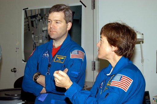 KENNEDY SPACE CENTER, FLA. -  In the Space Station Processing Facility, astronaut Stephen Frick and STS-114 Mission Specialist Wendy Lawrence watch as crew members work with equipment that will be used on the mission.  Frick is a tile specialist, who joined the STS-114 crew during equipment familiar