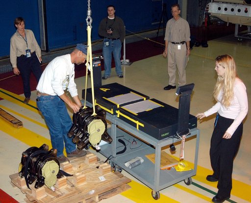 KENNEDY SPACE CENTER, FLA. -  Workers in the Orbiter Processing Facility stand by while another guides the lifting of one of two rudder speed brake actuators onto a table to measure the alignment of its bearings.  The actuators move an orbiter’s rudder, speed brake, elevons and main engines during f