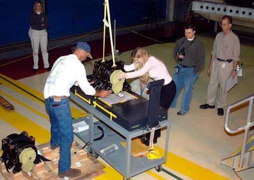 KENNEDY SPACE CENTER, FLA. -  Workers in the Orbiter Processing Facility settle into place one of two rudder speed brake actuators onto a table to measure the alignment of its bearings.  The actuators move an orbiter’s rudder, speed brake, elevons and main engines during flight.
