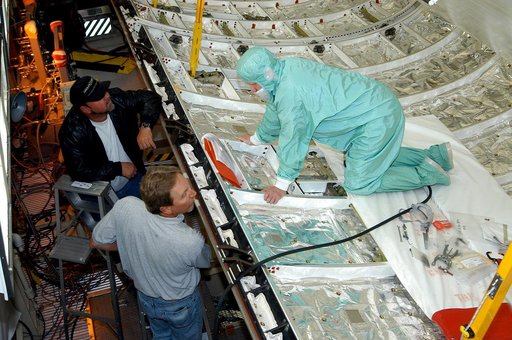 KENNEDY SPACE CENTER, FLA. -  A worker in the Orbiter Processing Facility checks part of the payload bay on Discovery.  The orbiter recently underwent an Orbiter Major Modification period, which included inspection, modifications and reservicing of most systems onboard. The work on Discovery also in