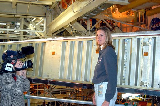 KENNEDY SPACE CENTER, FLA. -  In the Orbiter Processing Facility, Stephanie Stilson, NASA vehicle manager for Discovery, stands in front of a leading edge on the wing of Discovery.  She is being filmed for a special feature on the KSC Web about the recent Orbiter Major Modification period on Discove