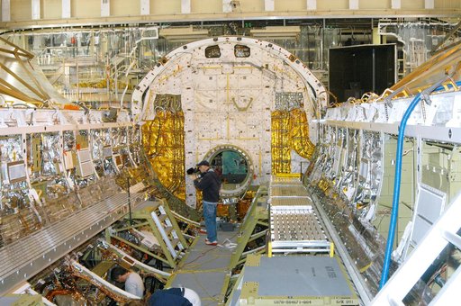 KENNEDY SPACE CENTER, FLA. -  In the Orbiter Processing Facility, a cameraman films part of Discovery’s payload bay for a special feature on the KSC Web.  In the background is the open hatch of the airlock, located inside the middeck of the spacecraft’s pressurized crew cabin. The airlock is sized t