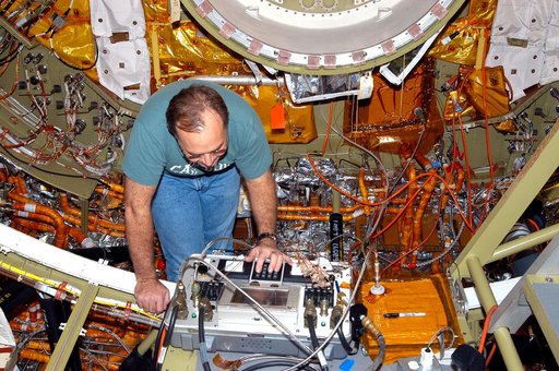 KENNEDY SPACE CENTER, FLA. -  In the Orbiter Processing Facility, a worker checks out part of the equipment in the airlock, at one end of Discovery’s payload bay.  The airlock is sized to accommodate two fully suited flight crew members simultaneously. Support functions include airlock depressurizat