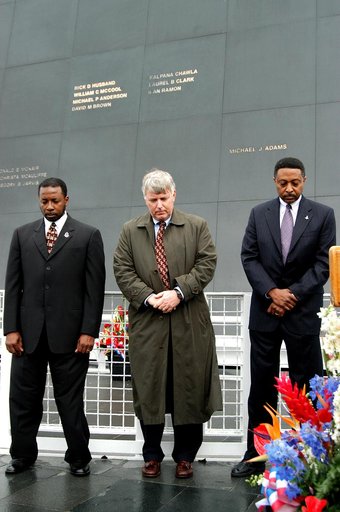 KENNEDY SPACE CENTER, FLA. -  Standing in front of the Space Memorial Mirror at the KSC Visitor Complex, KSC Deputy Director Woodrow Whitlow Jr., Center Director Jim Kennedy and Executive Director of Florida Space Authority Winston Scott bow their heads in prayer during a memorial service rememberin