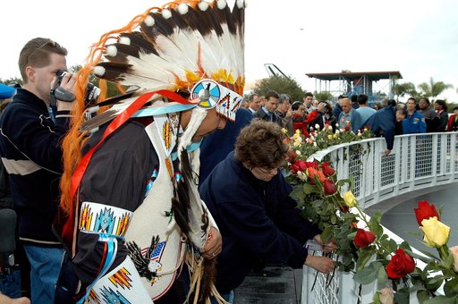 KENNEDY SPACE CENTER, FLA. -  Among the visitors placing flowers in the wire mesh fence surrounding the Space Memorial Mirror is one of the Indian dancers who performed a healing ceremony during a memorial service for the crew of Columbia.  Feb. 1 is the one-year anniversary of the loss of the crew 