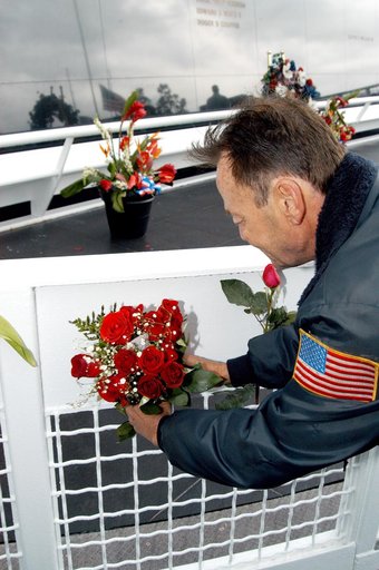 KENNEDY SPACE CENTER, FLA. -  Following the memorial service for the crew of Columbia at the Space Memorial Mirror, a visitor leaves a rose bouquet behind. Feb. 1 is the one-year anniversary of the loss of the crew and orbiter Columbia in a tragic accident as the ship returned to Earth following mis