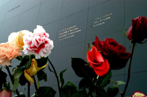 KENNEDY SPACE CENTER, FLA. - Brilliant roses and carnations frame the names of the Columbia crew carved onto the black granite surface of the Astronaut Memorial Mirror at the KSC Visitor Complex.  The flowers were left by visitors who attended a memorial service for the crew on the anniversary of th