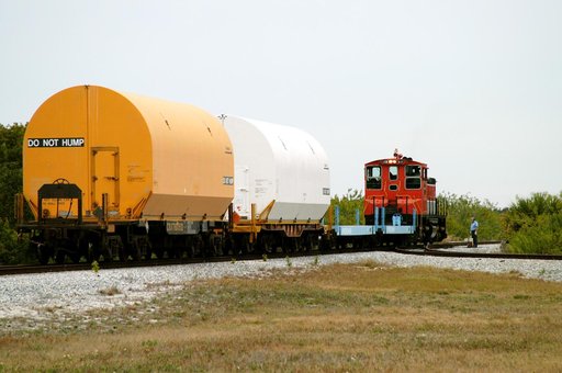 KENNEDY SPACE CENTER, FLA. - The red NASA engine hauls its cargo toward Titusville, Fla. The containers enclose segments of a solid rocket booster being returned to Utah for testing.  The segments were part of the STS-114 stack.  It is the first time actual flight segments that had been stacked for 
