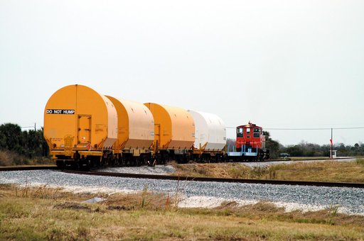 KENNEDY SPACE CENTER, FLA. - The red NASA engine hauls its cargo toward Titusville, Fla. The containers enclose segments of a solid rocket booster being returned to Utah for testing.  The segments were part of the STS-114 stack.  It is the first time actual flight segments that had been stacked for 