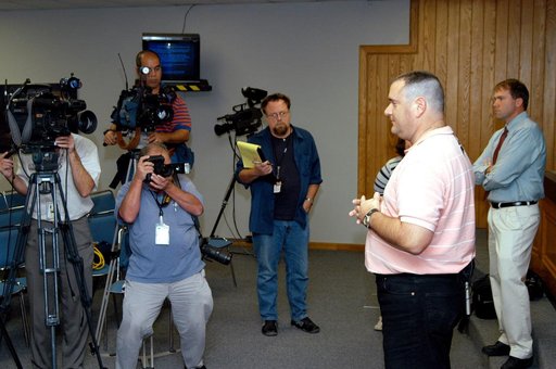 KENNEDY SPACE CENTER, FLA. - Armando Oliu, Final Inspection Team lead for the Shuttle program, speaks to reporters about the aid the Image Analysis Lab is giving the FBI in a kidnapping case.  Behind him at right is Mike Rein, External Affairs division chief.  Oliu oversees the image lab that is usi