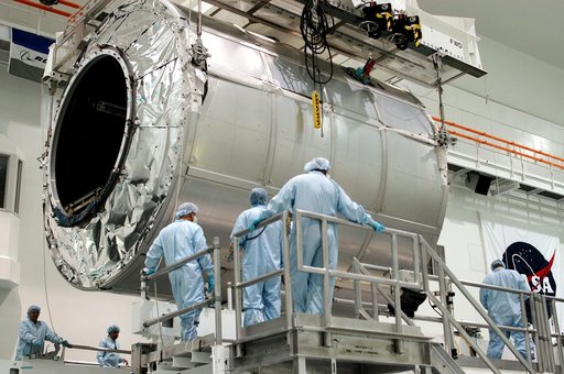 KENNEDY SPACE CENTER, FLA. - Workers watch as the Multi-Purpose Logistics Module Raffaello is lowered toward a work stand in the Space Station Processing Facility.  Raffaello is the second MPLM built by the Italian Space Agency, serving as a reusable logistics carrier and primary delivery system to 
