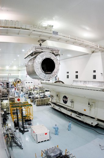 KENNEDY SPACE CENTER, FLA. - Overhead cables carry the Multi-Purpose Logistics Module Donatello from the payload canister (lower right) to a work stand in the Space Station Processing Facility.  Previously housed in the Operations and Checkout Building, Donatello was brought into the SSPF for routin