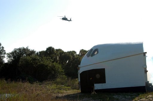 KENNEDY SPACE CENTER, FLA. - A helicopter approaches an orbiter crew compartment mock-up as part of a “Mode VII” emergency landing simulation at Kennedy Space Center.  The purpose is to exercise emergency preparedness personnel, equipment and facilities in rescuing astronauts from a downed orbiter a