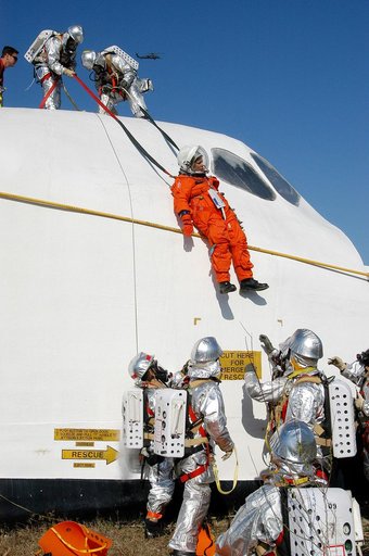 KENNEDY SPACE CENTER, FLA. - Emergency crew members lower a volunteer “astronaut” from the top of the orbiter crew compartment mock-up that is the scene of a “Mode VII” emergency landing simulation at Kennedy Space Center.  The purpose of the Mode VII is to exercise emergency preparedness personnel,