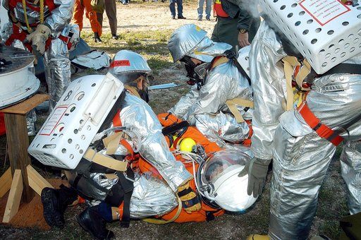 KENNEDY SPACE CENTER, FLA. - Emergency crew members help an injured astronaut after removing him from the orbiter crew compartment mock-up during a “Mode VII” emergency landing simulation at Kennedy Space Center.  The purpose of the Mode VII is to exercise emergency preparedness personnel, equipment