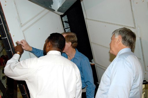 KENNEDY SPACE CENTER, FLA. - On a tour of the Orbiter Processing Facility, Deputy Director Woodrow Whitlow Jr. points to an area on a rudder speed brake panel on Endeavour that Tom Roberts, who is with United Space Alliance, is showing him.  At right is Center Director Jim Kennedy.  Endeavour is in 