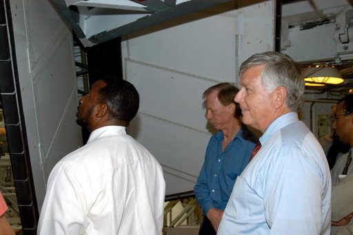 KENNEDY SPACE CENTER, FLA. - On a tour of the Orbiter Processing Facility, Center Director Jim Kennedy (right) and Deputy Director Woodrow Whitlow Jr. (left) look at rudder speed brake panels on Endeavour  In the background is Tom Roberts, who is with United Space Alliance.  Endeavour is in its Orbi