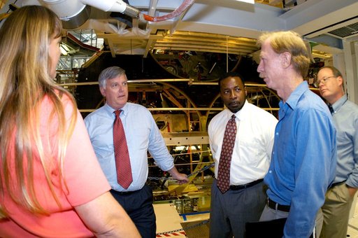 KENNEDY SPACE CENTER, FLA. - On a tour of the Orbiter Processing Facility, Center Director Jim Kennedy and Deputy Director Woodrow Whitlow Jr.  (center, left and right) talk with Kathy Laufenberg, Orbiter Airframe Engineering ground area manager,  and Tom Roberts, Airframe Enginering System speciali