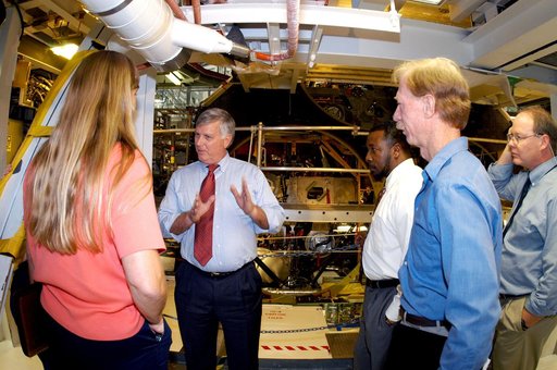 KENNEDY SPACE CENTER, FLA. - On a tour of the Orbiter Processing Facility, Center Director Jim Kennedy and Deputy Director Woodrow Whitlow Jr.  (center, left and right) talk with Kathy Laufenberg, Orbiter Airframe Engineering ground rea manager,  and Tom Roberts, Airframe Engineering System speciali