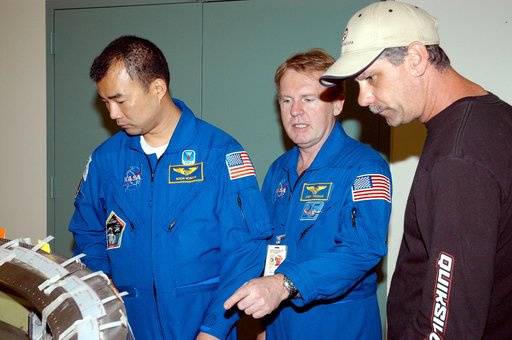 KENNEDY SPACE CENTER, FLA. -  Members of the STS-114 crew spend time becoming familiar with Shuttle and mission equipment.  Mission Specialists Soichi Noguchi (left) and Andrew Thomas (center) look at an engine eyelet, which serves as part of the thermal protection system on an orbiter.  Noguchi is 