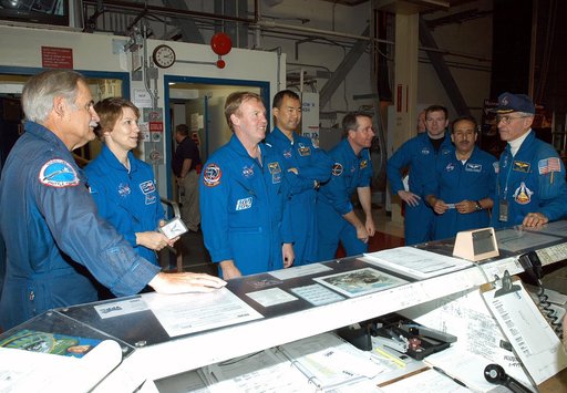 KENNEDY SPACE CENTER, FLA. - The STS-114 crew stands in front of the operations desk in the Orbiter Processing Facility.  At far right is astronaut John Young, who flew on the first flight of Space Shuttle Columbia with Robert Crippen. Young is associate director, Technical, at Johnson Space Center.