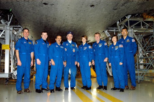KENNEDY SPACE CENTER, FLA. - The STS-114 crew stands underneath Discovery in the Orbiter Processing Facility.  From left are Mission Specialist Stephen Robinson, Pilot James Kelly, Mission Specialist Charles Camarda, astronaut John Young, Commander Eileen Collins and Mission Specialists Andrew Thoma