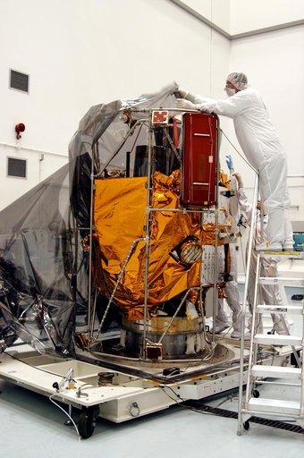 KENNEDY SPACE CENTER, FLA. -  In the high bay clean room at the Astrotech Space Operations processing facilities near KSC, workers remove the protective cover from NASA’s MESSENGER spacecraft.  Employees of the Johns Hopkins University Applied Physics Laboratory, builders of the spacecraft, will per