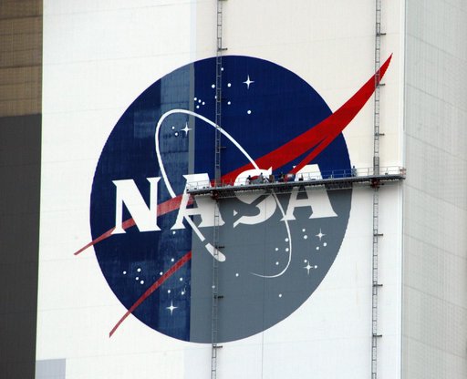 Workers painting the Flag and Meatball on the VAB