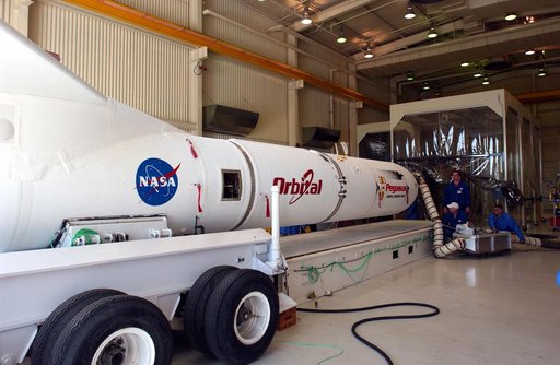 The mated Pegasus XL rocket - AIM spacecraft leaves Building 165