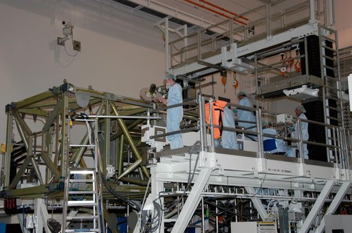 Workers prepare to connect cables that will recharge the battery