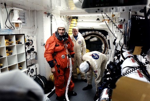 KENNEDY SPACE CENTER, FLA. -  STS-81 Mission Specialist Jeff Wisoff prepares to enter the Space Shuttle Atlantis at Launch Pad 39B with help from White Room closeout crew members Danny Wyatt (center) and Al Rochford.