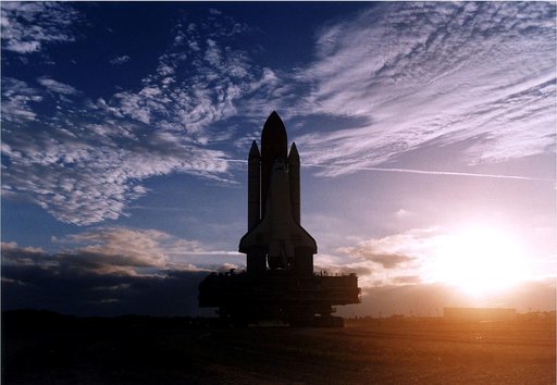 KENNEDY SPACE CENTER, FLA. -  The rising sun and some scattered clouds provide a picturesque backdrop for the Space Shuttle Discovery as it travels along the crawlerway toward Launch Pad 39A in preparation for the STS-82 mission.  The Shuttle is on a Mobile Launcher Platform, and the entire assembla