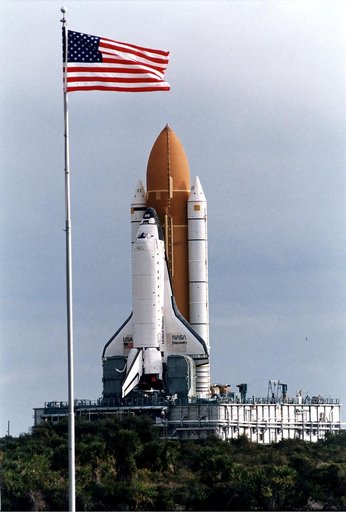 KENNEDY SPACE CENTER, FLA. -  The Space Shuttle Discovery on its Mobile Launcher Platform makes its slow 3.4-mile trek from the Vehicle Assembly Building to Launch Pad 39A in preparation for the STS-82 mission.  In the foreground is the U.S. flag at the Press Site area.  A seven-member crew will per
