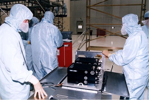 KENNEDY SPACE CENTER, FLA. -  Workers in KSC's Vertical Processing Facility prepare a solid state recorder for installation in a protective enclosure as part of the prelaunch preparations for STS-82, the second Hubble Space Telescope servicing mission.  The digital solid state recorder will replace 