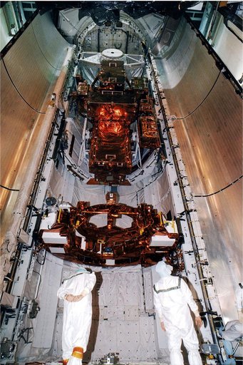 KENNEDY SPACE CENTER, FLA. -   At the KSC Launch Pad 39A, two members of the payload closeout crew check equipment as the doors are just about ready to be closed.  The Payload inside the bay of Discovery, the orbiter for the STS-82 mission, is ready for the launch of the second Hubble Space Telescop