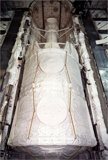 KENNEDY SPACE CENTER, FLA. - The Microgravity Science Laboratory-1 (MSL-1) Spacelab module is installed into the payload bay of the Space Shuttle Orbiter Columbia in Orbiter Processing Facility 1.  The Spacelab long crew transfer tunnel that leads from the orbiter's crew airlock to the module is als