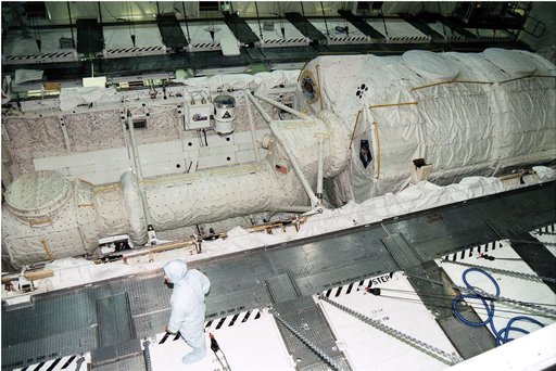 KENNEDY SPACE CENTER, FLA. - The Microgravity Science Laboratory-1 (MSL-1) Spacelab module is installed into the payload bay of the Space Shuttle Orbiter Columbia in Orbiter Processing Facility 1.  The Spacelab long crew transfer tunnel that leads from the orbiter's crew airlock to the module is als