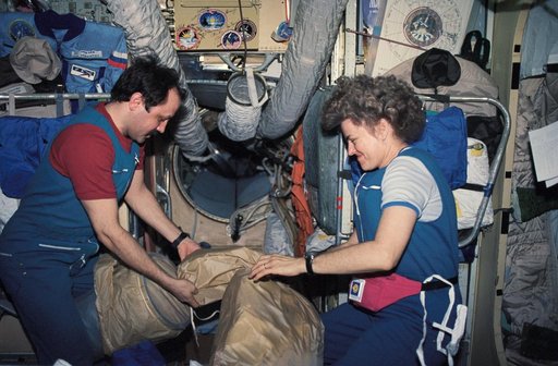 Mir 21 crew and Astronaut Lucid stowing equipment