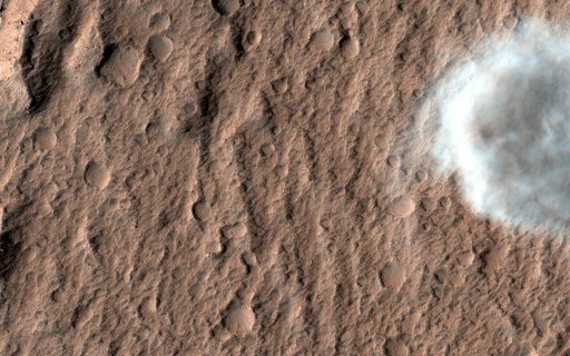 A Dust Devil on Hilly Terrain