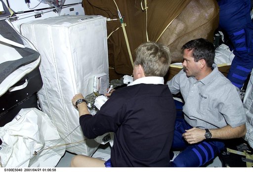 MS Parazynski and MS Hadfield look through a stowage bag on the middeck of Endeavour